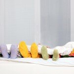 Happy family in colorful socks on white bed.