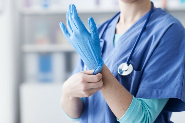 Female doctor wearing protective gloves, hands close up