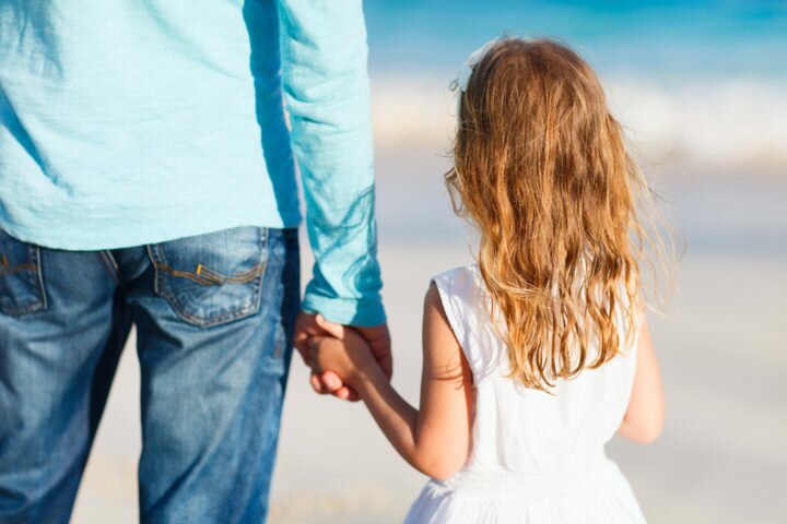 Adorable little girl holding her father hand